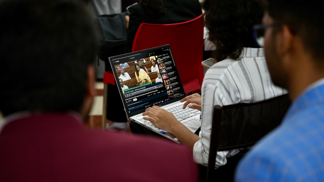 A group of people sitting around a table with laptops
